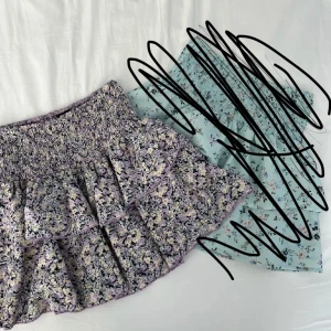 Ljuslila blommig volangkjol Gina Tricot - Supersöt kort volangkjol från Gina Tricot i ljuslila med blommigt mönster.