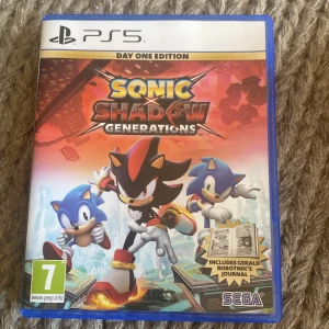 Sonic x Shadow Generations Day One Edition till PS5 - Sonic x Shadow Generations Day One Edition till PlayStation 5. Inkluderar exklusiv journal (Gerald Robotnik's Journal) och spel på skiva. Omslaget har färgstark design med Sonic och Shadow. PEGI 7. Perfekt för fans av action och plattformsspel. Säljer då det inte används, hoppas det får en ny ägare snart.