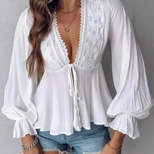 Vit blus med spets och knytband - Säljer en romantisk vit blus med djup v-ringning, spetsdetaljer och knytband framtill. Blusen har långa, vida ärmar med resår vid ärmslut och en lätt utsvängd passform. Perfekt för dig som gillar feminina detaljer och en luftig känsla. Jag har aldrig använt den bara provat!