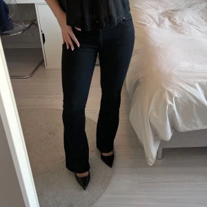 Svarta bootcut jeans - Snygga svarta jeans med bootcut-passform. Perfekta till både sneakers och klackar. Stilrena och enkla att matcha med olika toppar. Det är lite färg som ”skavts” av på knät men inget man tänker på 🥰