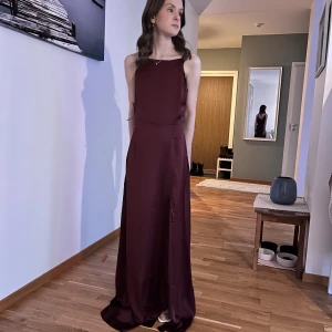 Vinröd balklänning - Jag säljer nu denna superfina vinröda balklänning⭐️ Jag har hittat en annan balklänning som jag har valt istället, och står nu med denna. Denna är verkligen såååå fin och letar nu efter en ny ägare som vill använda den.  Klänningen är vinröd med höghals, och djup rygg med spets på kanterna. Klänningen har även en slits vid låret. Klänningen är ganska lång för mig som är 160, men det är enkelt att lägga upp. Klänningen är helt oanvänd, endast testad och har prislappen kvar.  Kan skicka fler bilder