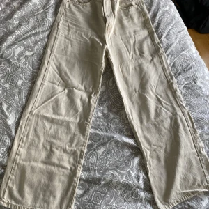 Beige jeansbyxor från Gina Tricot - Säljer ett par beige jeansbyxor från g perfect jeans i rak modell. Byxorna har klassisk femficksdesign, dragkedja och knapp framtill. Perfekta för dig som är ca 160cm lång.