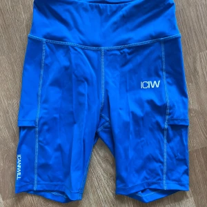 Blå träningstights shorts från ICANIWILL - Snygga blå träningstights shorts från ICANIWILL med hög midja och fickor på sidorna. Perfekta för gymmet eller löpning. Stretchigt material som sitter skönt och följsamt. Aldrig använda men saknar prislapp.