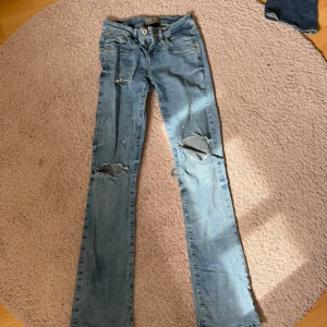 Ltb jeans med hål - Säljer ett par ljusblå jeans Low rise bootcut med egns gjorda hål från ltb det har ett hål där bak men är igen sytt och syns inte när man har på sig dom.   🤗🤗 Storlek w24 L34