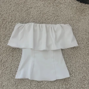 Vit offshoulder topp med volang från Zara - Super fin top från zara med volang, slutsåld finns inte mer. Inga defekter alls!!💞💞