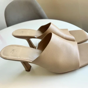 Beige slip-in klackar från H&M - Säljer ett par stilrena beige slip-in klackar från H&M. Använda 2-3 gånger, ganska nya. Storlek 38.