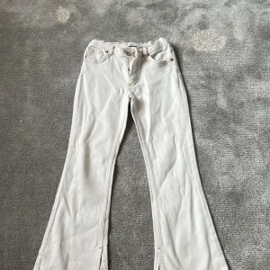 Vita bootcut jeans från Zara - Säljer ett par vita jeans från Zara st 140 med bootcut-passform och klassisk femficksdesign. Byxorna har hög midja och stängs med dragkedja och knapp. Perfekta för dig som gillar en retroinspirerad look med utsvängda ben. De har ett par fläckar som därför ger den rabatt. 