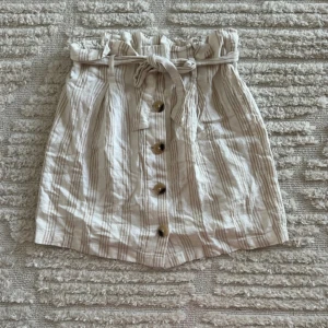 Randig kjol  - Kjol från Gina Tricot  Storlek 36 Använd fåtal gånger  Har knappar och snörning Använd fåtal gånger Normal i storlek!   NA-KD, BIKBOK, Gina Tricot, Zara, Mango