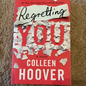 Regretting You (oanvänd) - Säljer boken 'Regretting You' av Colleen Hoover. Omslaget är rött med vit och svart text och har ett designmönster som ser ut som sönderrivet papper. Boken är på engelska och utgiven av Montlake.