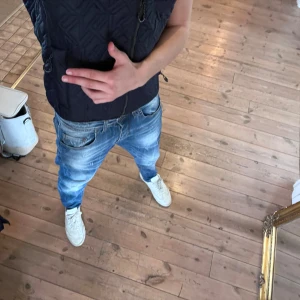 Italienska jeans med snygg tvätt  - Säljer ett par blå jeans från italien med slitna detaljer och tvättad look. Jeansen har fem fickor, normal passform och är tillverkade i bomull med lite stretch för extra komfort. Perfekta för en avslappnad stil. Unikt snygga 🤩