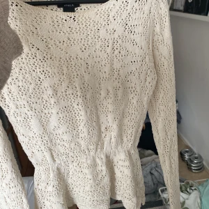Beige spetsblus  - Säljer en söt beige spetsblus från Lindex. Blusen har långa ärmar och en fin volangdetalj vid nederkanten. Perfekt för en stilren look. Hör av dig vid intresse!