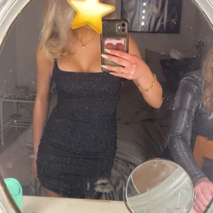 Glittrig klänning  - Har tyvärr bara en bild på hur den ser ut men den har en korsad knytning bak till. Använd 2 gånger!