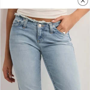 No waist bootcut jeans  - Snygga ljusblå bootcut jeans med fransig kant vid midjan. Perfekta för en avslappnad stil med en touch av edge. De har en klassisk femficksdesign och en knappgylf. Använda 2 ggr.