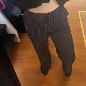 Randiga kostymbyxor från BikBok - Snygga randiga kostymbyxor från BikBok i mörkblått med vita ränder. Byxorna har en klassisk passform med hög midja och raka ben. Storlek 34 men passar 36 med 💖