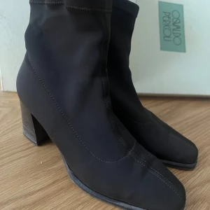 Vintage! Svarta stövletter från Osvaldo Pericoli - Snygga svarta stövletter från Osvaldo Pericoli med en elegant klack och rund tå. Tillverkade i ett mjukt material som ger en bekväm passform. Perfekta för att ge en stilren touch till din outfit.