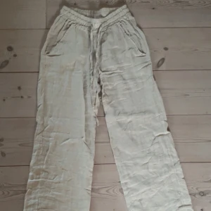 Beige linnebyxor med snörning - Säljer mina linnebyxor från Chelsea, tror jag köpte dem för 500/600kr. Använda 1 gång och inga tecken på skador. Väldigt fina och bekväma men används tyvärr inte