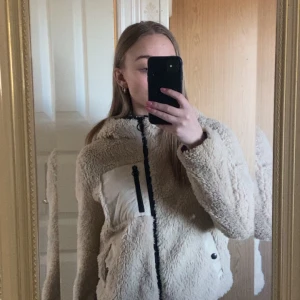 Kort teddyjacka  - Fin teddyjacka från Vero Moda köpt för tre år sedan. Lite mer fodrad modell samt har luva. Nypris 550kr, mycket sparsamt använd🩷