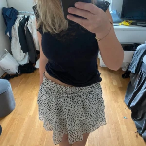 Vit och svart prickig kjol - Säljer en söt vit kortkjol med svarta prickar. Från Chelsea i storlek S