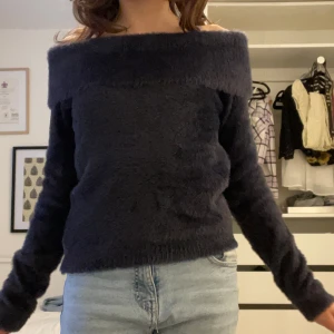 Svart fluffig offshoulder tröja  - Säljer en mysig mörkblå offshoulder tröja från Kappahl. Tröjan har en fluffig textur och långa ärmar, perfekt för kyligare dagar. Den är stilren och kan enkelt matchas med olika outfits. Perfekt för dig som vill ha något bekvämt och snyggt!Den är aldrig använd och har fortfarande prislappen på. Jag säljer den för att den inte riktigt är min stil❤️Nypris var 350kr men jag säljer för 200kr eftersom den är ny 