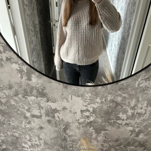 Beige stickad tröja - Mysig beige stickad tröja med grovt mönster. Tröjan har långa ärmar och en avslappnad passform, perfekt för kyligare dagar. Den är enkel att matcha med jeans eller leggings för en bekväm look.