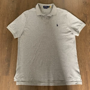 Ralph lauren piké  - En otroligt fin Ralph lauren piké som är helt oanvänd, (endast tvättad). Perfekt nu inför sommaren. Fin färg med kombinationen av mörkblå som passar till allt. Skriv privat vid minsta fundering. 