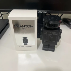 Phantom Parfum från Paco Rabanne - Säljer en unik Phantom Parfum från Paco Rabanne. Flaskan har en cool robotdesign i svart med futuristiska detaljer. Perfekt för den som vill ha en doft med stil och attityd. Kommer i originalförpackning.
