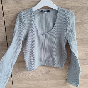 Ribbad croptop från Chiquelle - Ljusturkos ribbad och croppad topp från Chiquelle i strlk XS/S. Toppen har en rund halsringning och långa ärmar, aldrig använd. Ej i butik längre, nypris var runt 200kr.