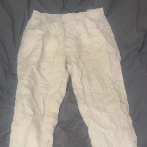 Beige linnebyxor från H&M - Säljer ett par bekväma beige linnebyxor från H&M. Byxorna har en elastisk midja och är perfekta för en avslappnad stil. De är tillverkade i ett lätt och luftigt material som passar bra för varmare väder.