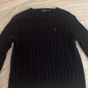 Marinblå kabelstickad tröja från Polo Ralph Lauren - Säljer en snygg marinblå kabelstickad tröja från Ralph Lauren. Säljer då den inte passar mig som jag tänkt. Classy och passar till formella samt casual outfits. Ny pris 2200 