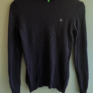 Svart tröja från United Colors of Benetton - Säljer en stilren svart tröja från United Colors of Benetton. Tröjan är tillverkad i en mjuk blandning av ull, polyamid, viskos och kashmir. Den har långa ärmar och en klassisk rund halsringning. 