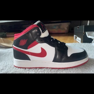 Nike Air Jordans i svart, vitt och rött - Snygga Nike Air Jordans som knappt är använda. Storlek 40 men passar även folk med 39. Skon har en snygg röd sula. Säljer för att dem är för små