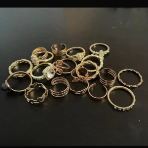 Samling av guld- och bronsfärgade ringar - Säljer en samling av olika guld- och bronsfärgade ringar. Vissa ringar har pärldetaljer och andra har unika mönster och former. Perfekt för att mixa och matcha till olika outfits.