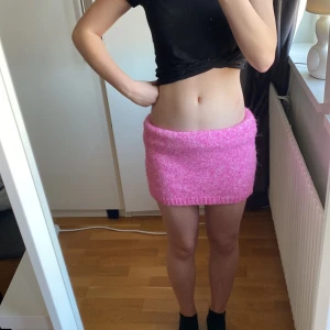 Rosa stickad kjol - Säljer en söt rosa stickad kjol som är perfekt för att ge en färgklick till din outfit. Kjolen har en tight passform och är gjord i ett mjukt material som känns skönt mot huden. Den är enkel att matcha med olika toppar och accessoarer. Stl 146