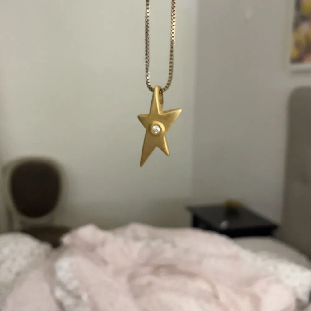 Elegant halsband med ett stjärnformat hänge i guld. Hänget har en liten kristal i mitten som är så himla fin . Perfekt för att lysa upp vilken outfit som helst. Jag har knappast använt halsbandet och är i nyskick. Asusteet.
