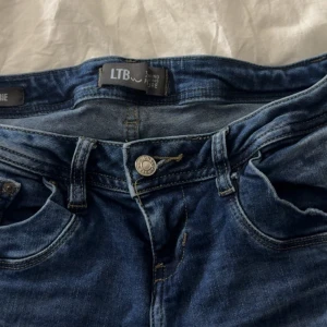 Blå slitna jeans från LTB - Säljer ett par blå jeans från LTB med slitna detaljer och snygg tvätt. Jeansen har klassisk femficksdesign, dragkedja och knapp framtill samt slitningar på benen.