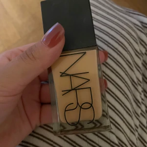 NARS Foundation Sahel - Flytande foundation från NARS i nyansen Sahel. Kommer i en stilren glasflaska med svart lock och stor NARS-logga. Nyansen är ljus till medium med varm underton, perfekt för en naturlig bas. Innehåller 30 ml.