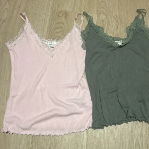 2 ribbade linnetoppar med spets Amisu - Två söta linnetoppar från Amisu, en ljusrosa och en grågrön. Båda har tunna axelband, v-ringning med spetskant och ribbad struktur. Perfekta att styla lager på lager eller till jeans. Säljes tillsammans! Och rosa är strl M och gröna strl S☺️💗💚