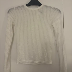 Vit långärmad topp från H&M (tror jag) - Säljer en vit långärmad topp från H&M (tror jag) med smala, diskreta ränder och öppen rygg med knut. Tunt, lätt material som känns luftigt och fräscht. Aldrig använd! Köparen står alltid för frakten 💞