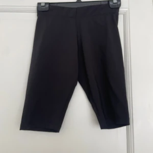 Svarta cykelshorts från Only XS - Svarta cykelshorts från Only i stretchigt material. De har en midwaist passform och är knälånga, perfekta för träning eller chill. Snygg och enkel design utan detaljer eller mönster, passar till allt.