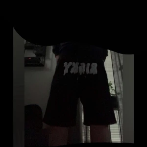 Svarta risky shorts  - Svarta shorts med ljusblå text i graffiti-stil. Modellen är loose fit . Perfekta för chill eller streetwear-vibe. 