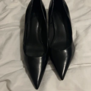 Svarta pumps med spetsig tå - Klassiska svarta pumps i skinn med spetsig tå och låg klack. Snygg minimalistisk design som passar perfekt till både dressade och mer avslappnade outfits. Tidlösa och enkla att matcha med det mesta.
