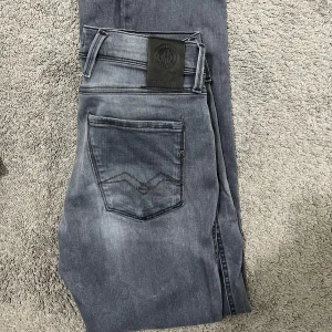 Replay Anbass Grå jeans 30/32 - Snygga Replay Anbass grå jeans i storlek 30/32. Skick 8,5/10. Inga deffekter alls! Använt normalt då och då, men sparsamt därav väldigt bra skick. Har du fler frågor tveka inte att höra av dig😀