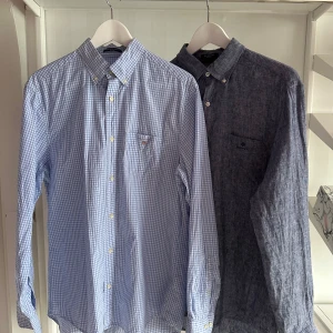 Två långärmade gant skjortor, blå & grå - Säljer 2 gant skjortor som aldrig är använda bara tvättade. Passformen är regular, jag säljer de tillsammans men kontakta mig om du bara vill ha 1