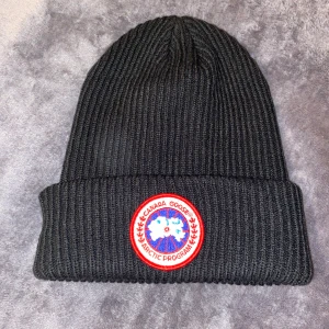 Canada Goose Mössa - Svart Canada Goose mössa i storlek Onesize!  Använd ett fåtal gånger under korta perioder!  Helt fräsch och kommer från ett hem utan husdjur samt rökfritt!  Vid köp så packar jag och skickar din beställning samma dag eller dagen efter beroende på vad klockan är vid köpet! 😊  Vid fler frågor - Tveka inte på att skriva så svarar jag så fort jag har möjlighet! ⭐️