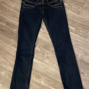 Mörkblå bootcut jeans från Pepe - Snygga mörkblå jeans från Pepe med bootcut passform och klassiska kontrastsömmar. Jeansen har låg midja. köpta på sellpy!