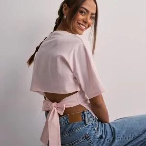 Rosa open back tie topp - Säljer en superfin rosa topp med öppen rygg och knytning från Nelly!! endast använd en gång💞