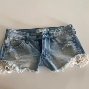 Lågmidjade jeansshorts med spets - Säljer söta lågmidjade jeansshorts från Abercrombie & Fitch i ljusblå denim. Inga hål eller fläckar ❤️