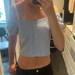 Ljusblå broderad blus med puffärm - Superfin ljusblå blus med broderade blommor och puffiga korta ärmar. Toppen är croppad, har knappar framtill och kan bäras offshoulder skriv om du har några frågor 💕💕