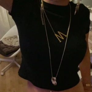 Svart ribbad topp från H&M - Säljer en svart ribbad topp från H&M Basic. Toppen har en tight passform och korta ärmar, perfekt för en stilren look. Den är enkel att matcha med olika outfits.