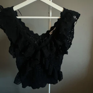 Svart spetsblus med volang från Zara - Säljer en svart blus från Zara i spets med v-ringning och volangdetaljer. Buda gärna då det är väldigt många intresserade 